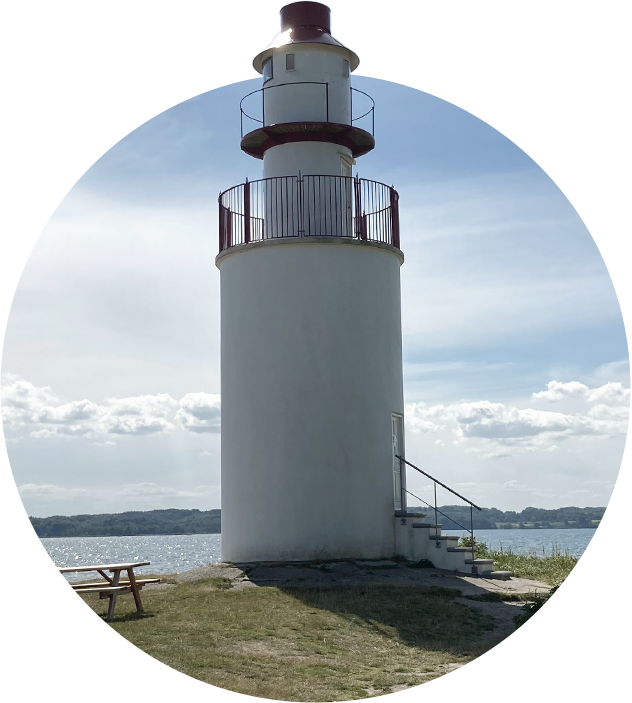 Leuchtturm am Meer mit einer Holzbank